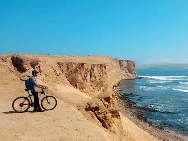 Ciclista recorriendo la carretera desértica del circuito de la Reserva Nacional de Paracas